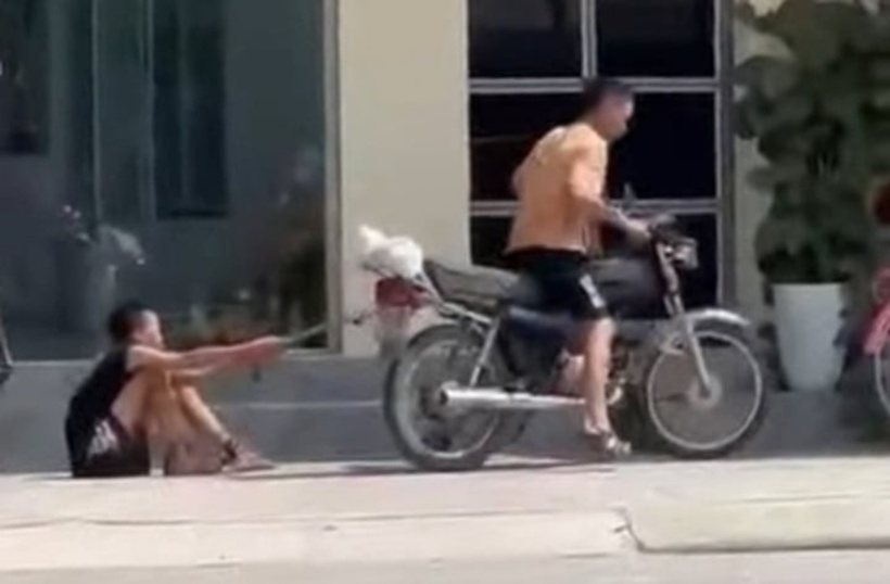 Hình ảnh người đàn ông kéo lê bé trai trên đường gây phẫn nộ. Ảnh: Cắt từ clip