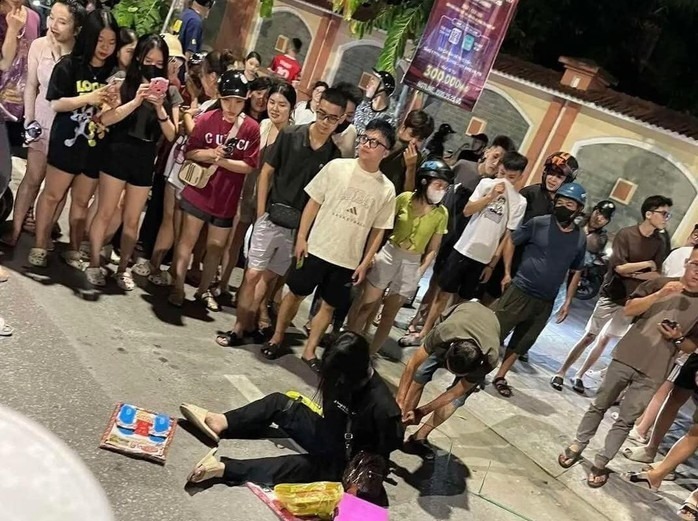 Người dân khống chế cô gái trẻ có hành vi đập phá tại sản. (Ảnh: Người lao động)