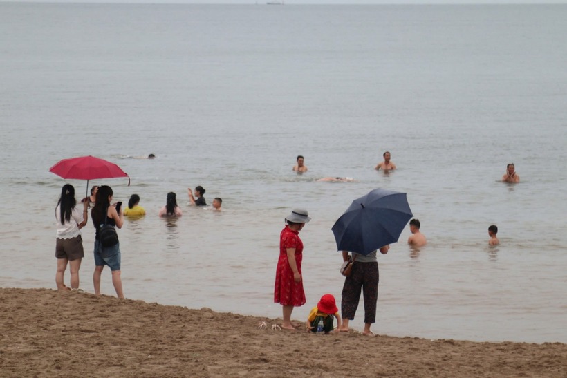 Không chỉ người lớn mà trẻ em cũng vô tư nô đùa với sóng biển, bất chấp nguy hiểm. (Ảnh: Tiền phong)