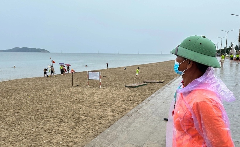 Ông Nguyễn Văn Thân - nhân viên cứu hộ, cứu nạn biển Cửa Lò - liên tục dùng còi, nhắc nhở du khách không tắm biển. (Ảnh: Tuổi trẻ)