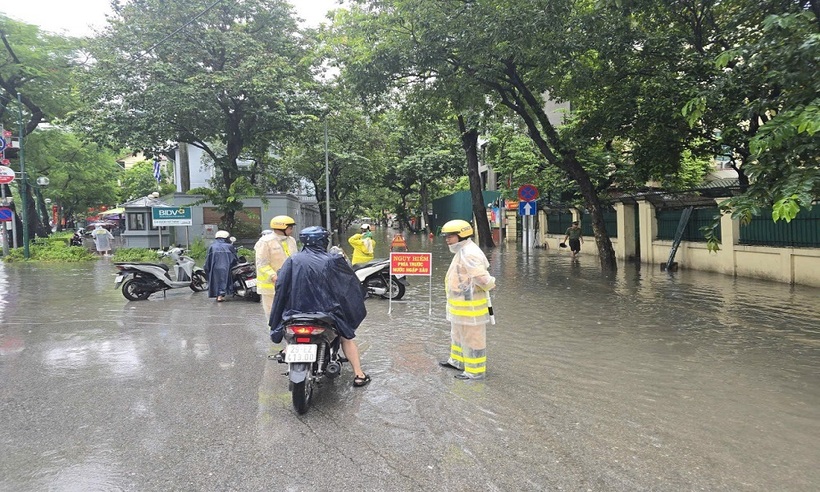 Lực lượng CSGT túc trực tại đầu phố ngập nước hướng dẫn người dân di chuyển theo hướng khác.