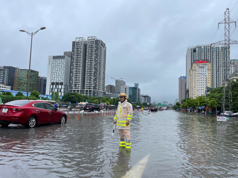 Cán bộ CSGT đường bộ số 6 phân luồng, hướng dẫn phương tiện tránh khu vực ngập sâu.