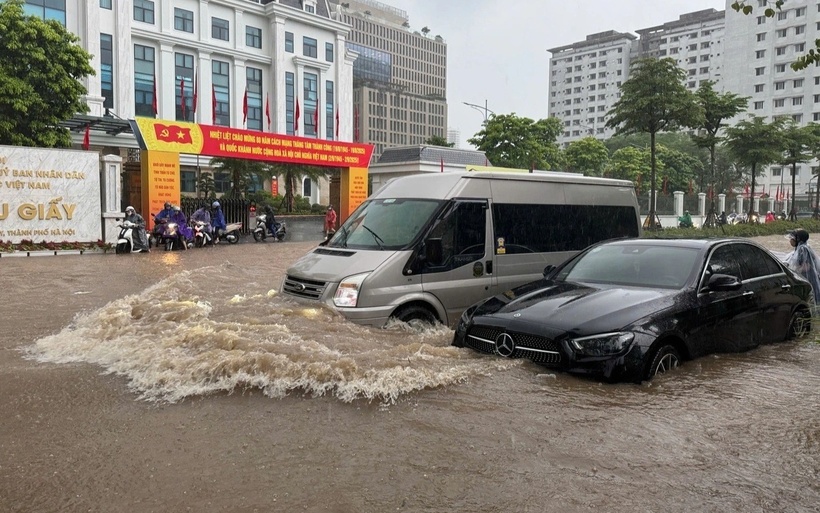 Ô tô di chuyển khó khăn giữa dòng nước sâu trên đường Trần Thái Tông, trước cổng UBND phường Cầu Giấy, Hà Nội. (Ảnh: Dân trí)