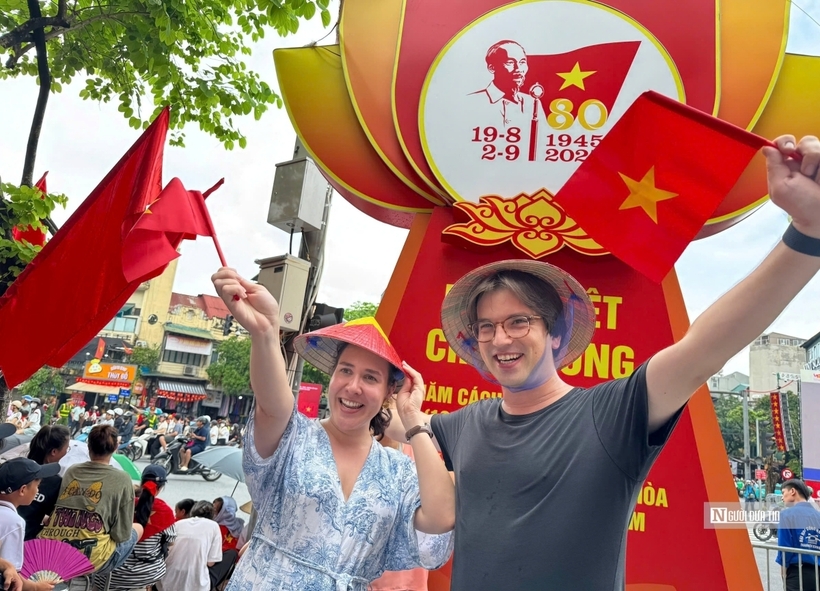 Hai du khách hào hứng khi được xem sự kiện diễu binh, diễu hành tại Việt Nam. Ảnh: Người Đưa Tin
