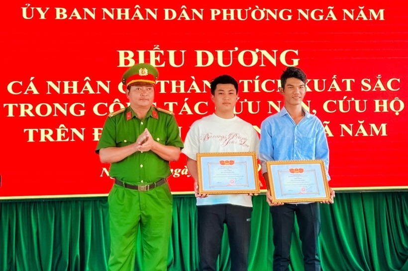 Lãnh đạo Công an phường Ngã Năm trao giấy khen của UBND phường đến 2 anh Đăng và Nhựt. Ảnh: Báo Dân trí.