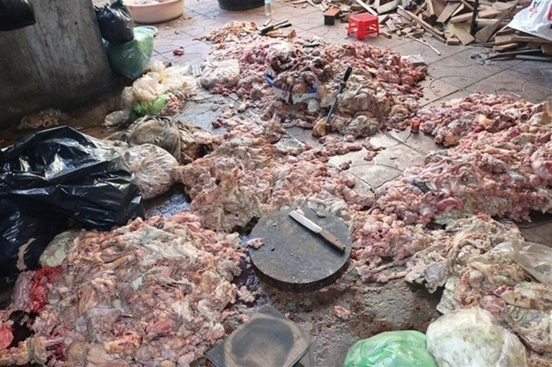 Bà Vịnh đang sơ chế mỡ lợn trực tiếp trên nền nhà bằng dao, thớt. Ảnh: Báo Thanh niên.