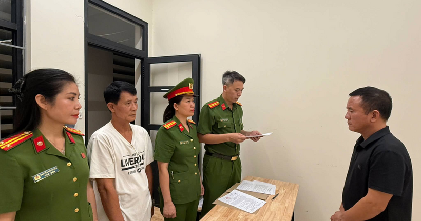 Cơ quan chức năng tống đạt quyết định khởi tố bị can (Ảnh: Công an cung cấp).