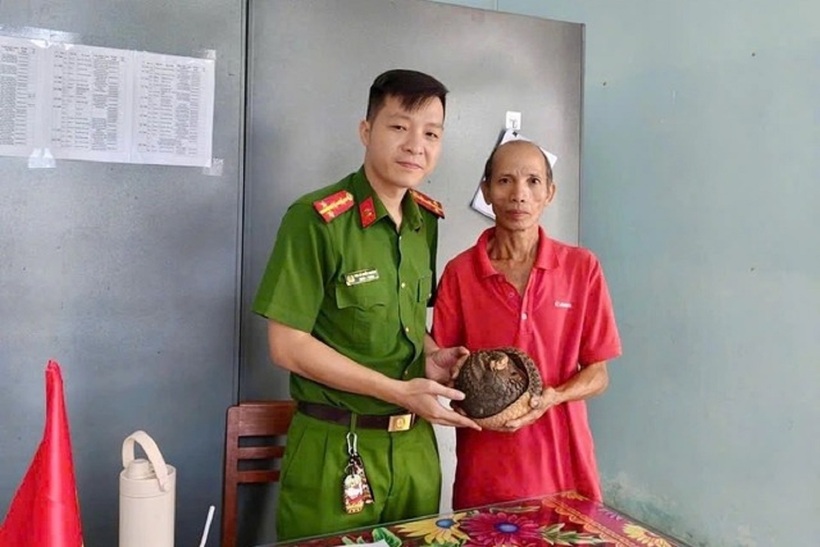 Ông Phạm Tấn Vinh giao nộp con tê tê cho công an. Ảnh: Thanh Niên