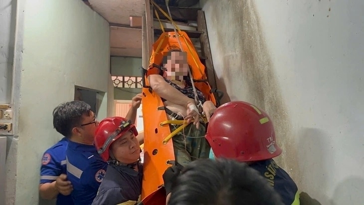 Cảnh sát giải cứu người phụ nữ bị sốt cao, mắc kẹt trên tầng hai trong căn nhà ở phường Diên Hồng. Ảnh: Tuổi trẻ