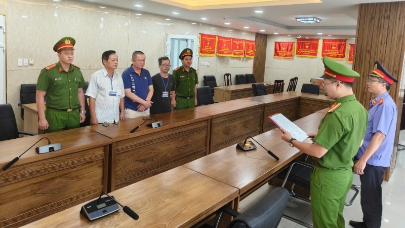Cơ quan điều tra tống đạt các quyết định khởi tố đối với ba bị can. (Ảnh: Công an cung cấp/Nhân dân)