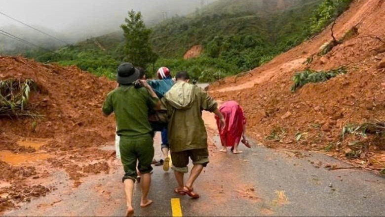 Các lực lượng dùng cáng khiêng bộ suốt 2 giờ đồng hồ trên tuyến đường sạt lở để đưa sản phụ đi sinh. (Ảnh: Tiền phong)