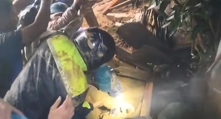 Lực lượng chức năng bới trong lớp bùn đất để đưa nạn nhân ra ngoài. Ảnh: VTC News