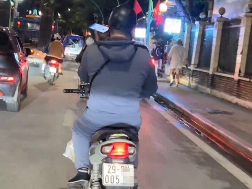 Hình ảnh thanh niên sử dụng điện thoại di động khi đang điều khiển xe được người dân ghi hình.