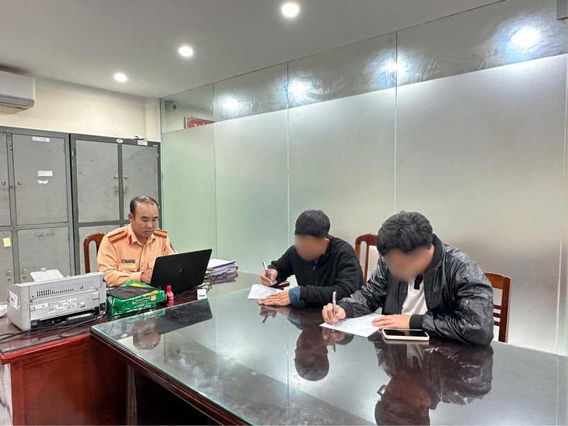 Cán bộ Phòng CSGT làm việc với tài xế ô tô gây tai nạn và người đứng ra nhận thay. Ảnh: VietNamNet