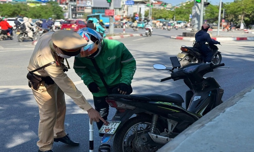 Tài xế xe ôm công nghệ che, dán biển số xe.