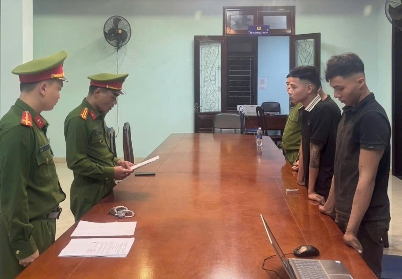 Công an đọc lệnh khởi tố, bắt tạm giam các đối tượng. Ảnh: Tiền Phong