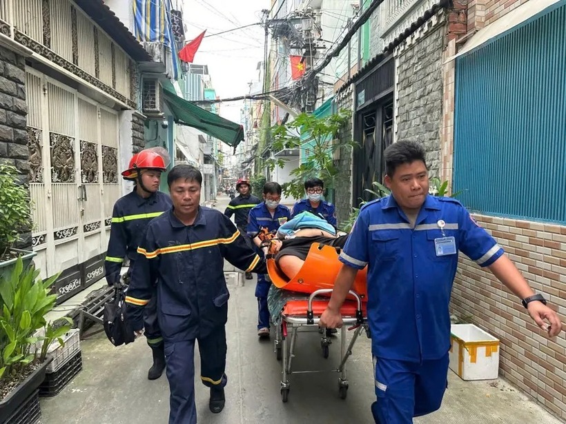Người đàn ông được lực lượng cảnh sát PCCC&CNCH đưa xuống đất an toàn. (Ảnh: Pháp luật TP.HCM)