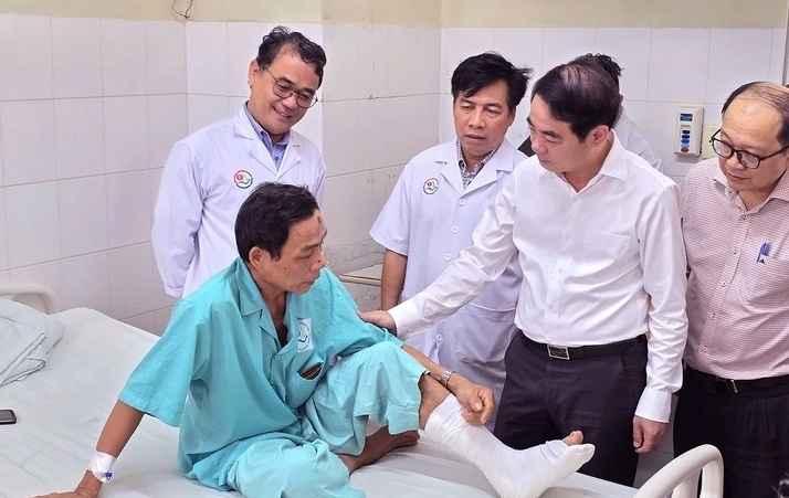 Bí thư Tỉnh ủy Khánh Hòa Nghiêm Xuân Thành thăm hỏi 1 nạn nhân bị thương vụ sạt lở trên đèo Khánh Lê đang điều trị tại Bệnh viện Đa khoa tỉnh Khánh Hòa. (Ảnh: Tuổi trẻ)