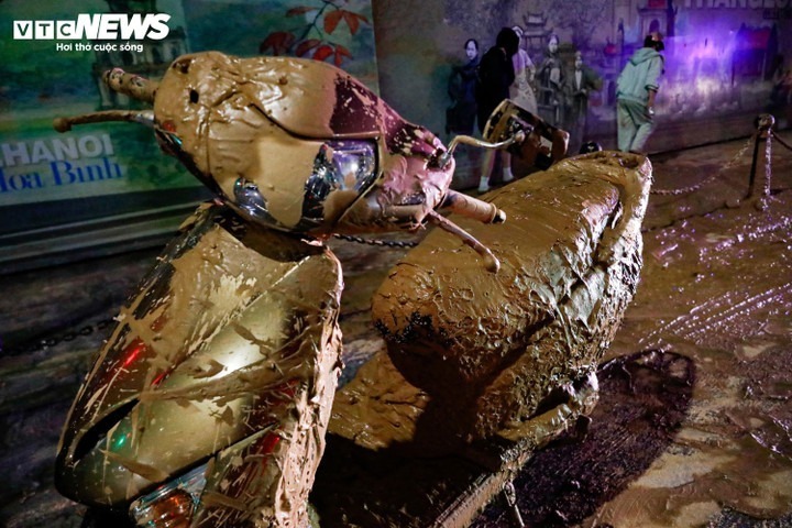 Nhiều người đi xe máy ngã sõng soài do bùn rơi vãi xuống đường. Ảnh: VTC News