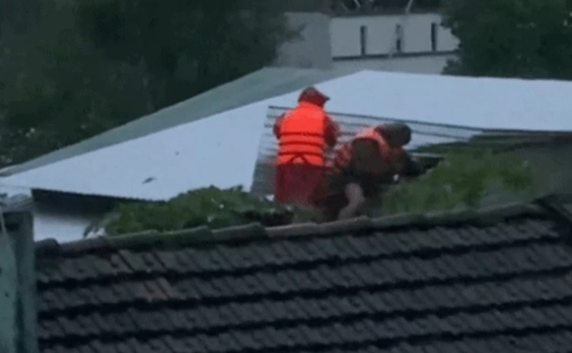 Cơ quan chức năng cạy mái nhà cứu người bị mắc kẹt do mưa lũ ở xã Đồng Xuân. (Ảnh: Dân trí)