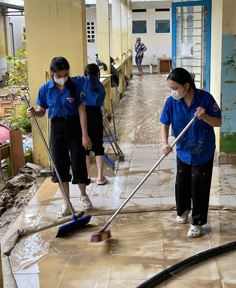 Giảng viên, sinh viên Trường Đại học Khánh Hòa hỗ trợ các đơn vị dọn dẹp sau khi nước rút.
