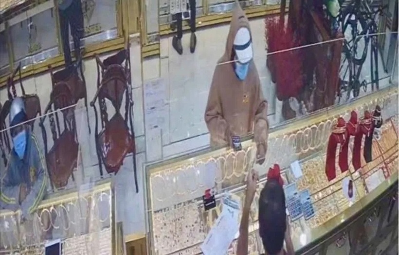 Nam thanh niên mặc áo khoác, đội mũ bảo hiểm và đeo khẩu trang bước vào tiệm vàng này hỏi mua dây chuyền. Ảnh: PLO.