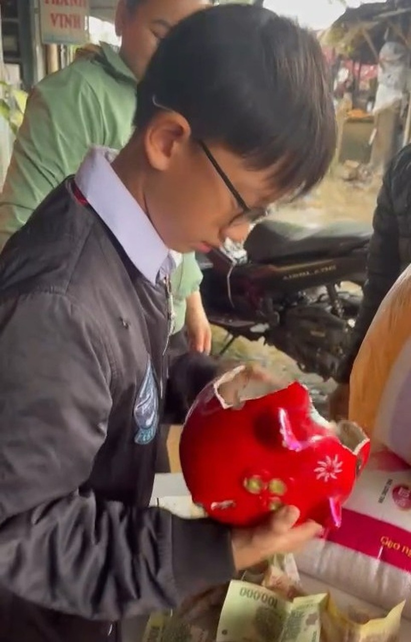 Cháu Tài được bố chở ra điểm tập kết hàng hóa ủng hộ người dân vùng lũ tỉnh Đắk Lắk. Ảnh: Dân trí