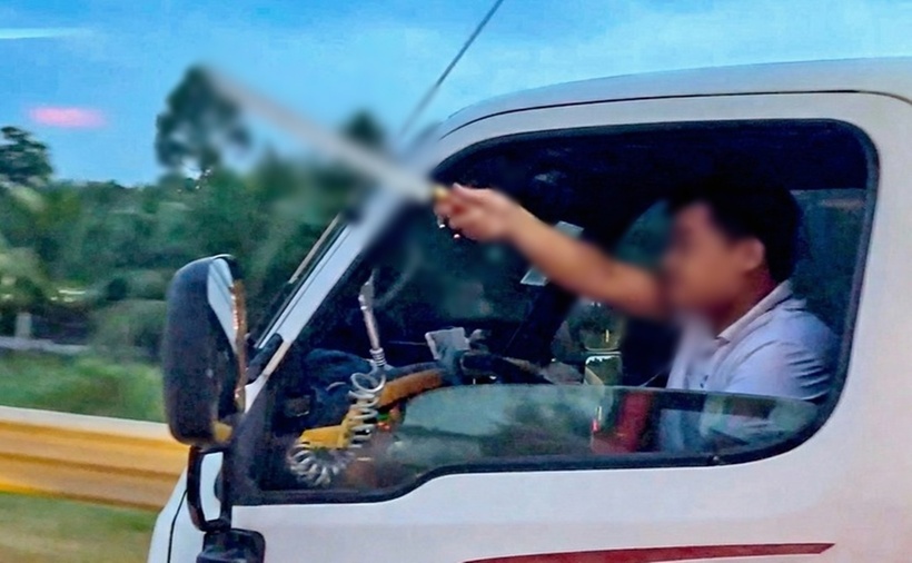 Tài xế cầm dao tự chế, thò ra ngoài cửa xe, nghi dọa chém người khác trên cao tốc Trung Lương - Mỹ Thuận. (Ảnh: Tuổi trẻ)
