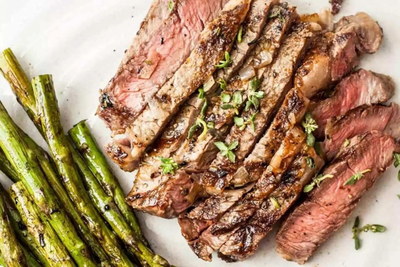 Cắt thịt bò thành lát vừa ăn, bày ra dĩa cùng với măng tây xào.
