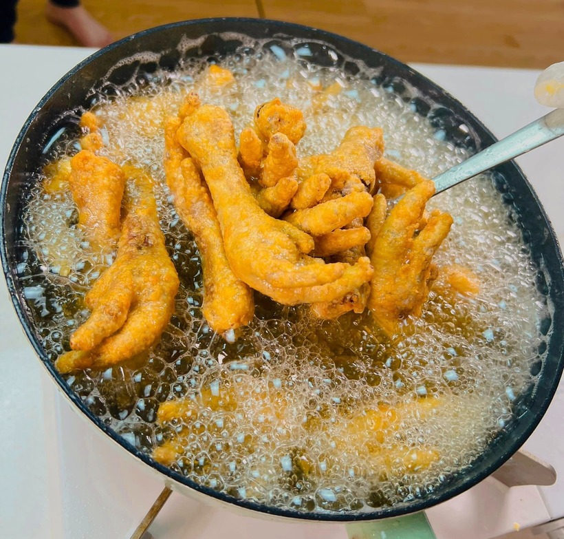 Chiên cho đến khi thấy chân gà săn lại, lớp bột bên ngoài bắt đầu vàng thì tắt bếp, vớt chân gà ra rây cho ráo bớt dầu.