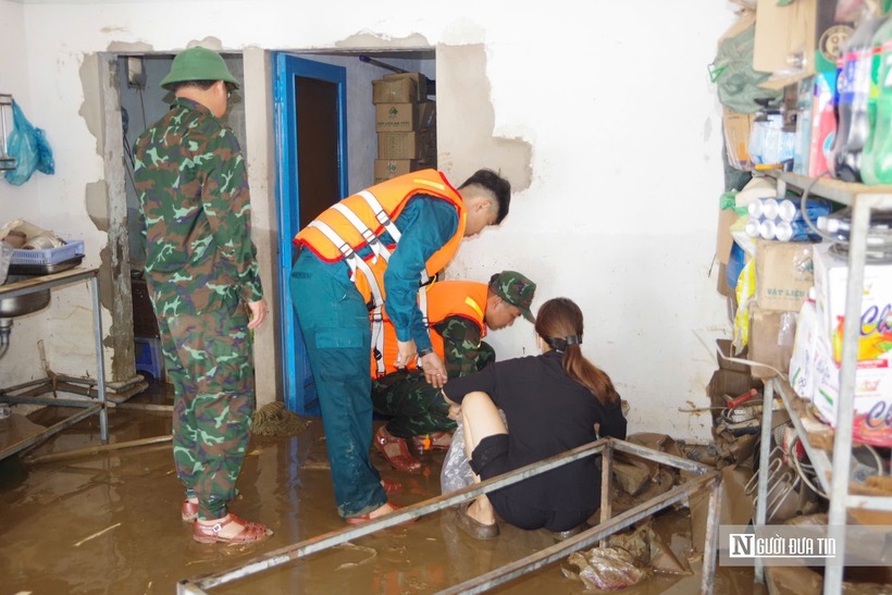 Cán bộ, chiến sĩ Ban Chỉ huy Phòng thủ khu vực 5 - Phan Thiết giúp người dân dọn dẹp sau khi lũ rút ở phường Hàm Thắng.