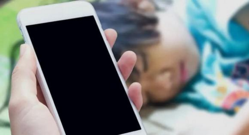 Trẻ đã ngủ, bố mẹ nằm chơi điện thoại bên cạnh. Ảnh minh họa