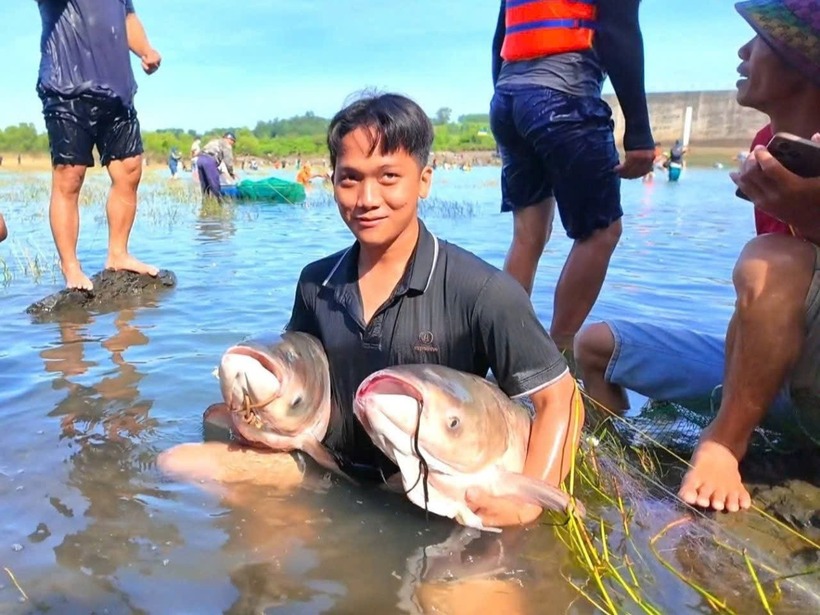 Nhiều người tập trung bắt cá sau khi nhà máy thủy điện ngưng xả tràn. Ảnh: Tiền Phong.