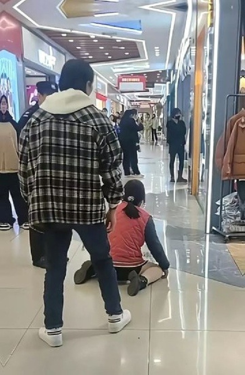 Sau cuộc cãi vã, người đàn ông bỏ đi, để mặc người vợ vẫn quỳ giữa trung tâm thương mại. Ảnh:&nbsp;Stheadline.