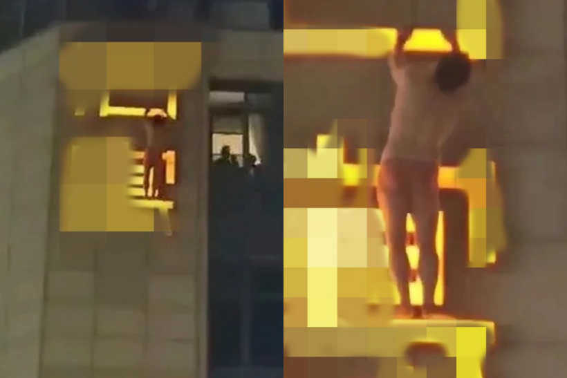 Người đàn ông treo lơ lửng trên biển hiệu.