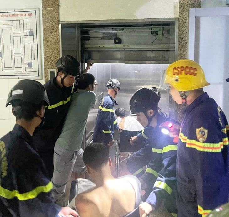 Lực lượng chức năng đưa những người bị mắc kẹt trong thang máy ra ngoài. (Ảnh: Tuổi trẻ)