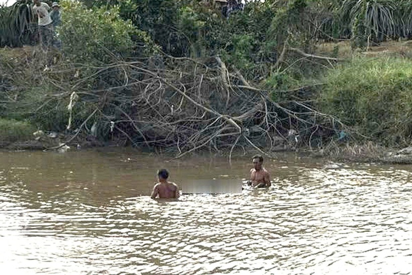 Người dân cùng lực lượng chức năng vớt thi thể nạn nhân lên bờ. (Ảnh: Dân trí)