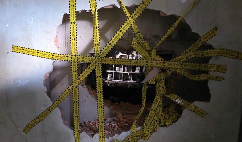 Bức tường bị đập để thông vào được cửa hàng, thực hiện cứu hộ nạn nhân. (Ảnh: Dân trí)