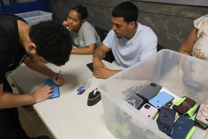 Học sinh trung học tại thành phố New York nộp smartphone trước khi vào lớp. Ảnh: Tuổi trẻ/JAMES MESSERSCHMIDT