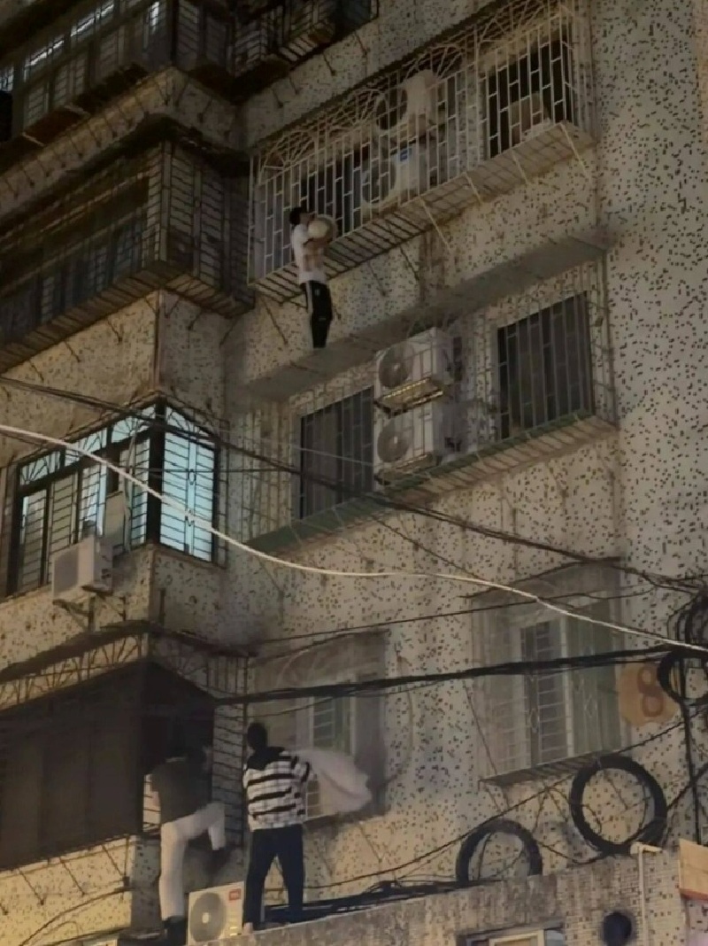 Màn giải cứu bé trai treo lơ lửng ngoài ban công tầng 4. Ảnh: News.