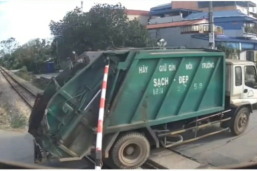Hình ảnh xe chở rác vượt qua đường sắt khi cần chắn tự động đã hạ xuống. Ảnh: Dân Trí