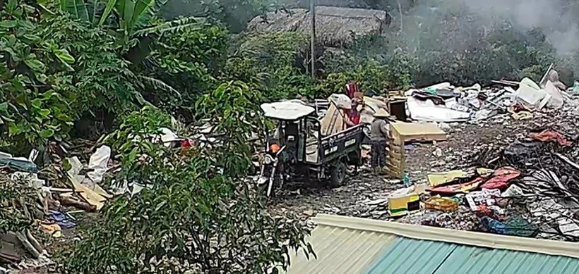 Lực lượng chức năng phát hiện tài xế xe ba gác chở xà bần, ván ép,... tới đổ ở khu đất. Ảnh: PLO.