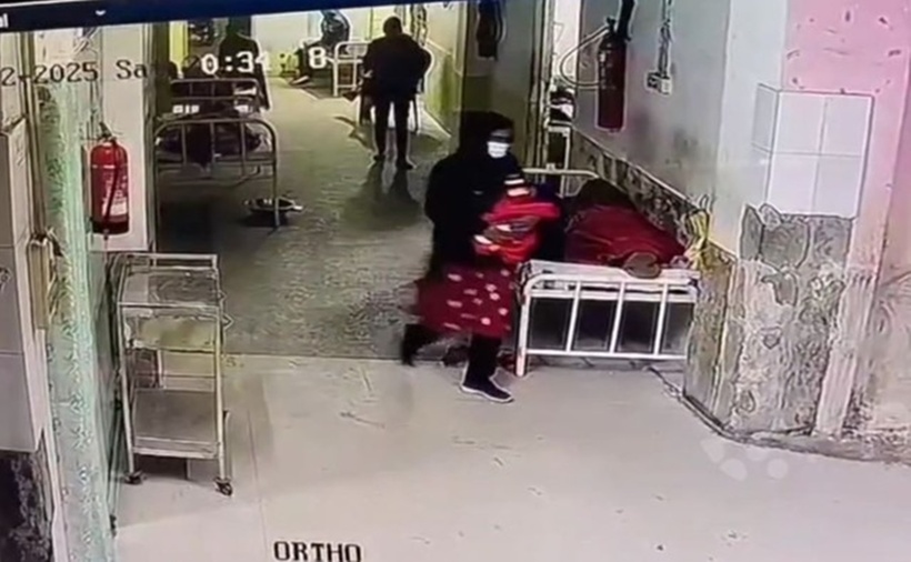 Người phụ nữ bế đứa trẻ ra khỏi bệnh viện.