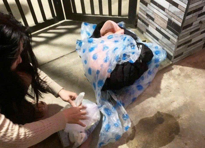 Bé trai được quấn trong áo ấm, kèm theo quần áo đặt trong một túi ni-lông. Ảnh: Người lao động