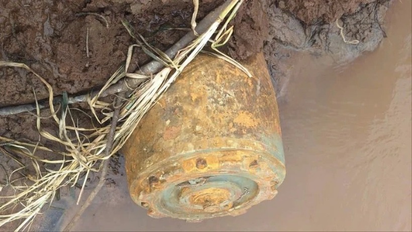 Quả bom nặng hơn 330kg nằm ở bờ suối. Ảnh: Pháp luật TP.HCM
