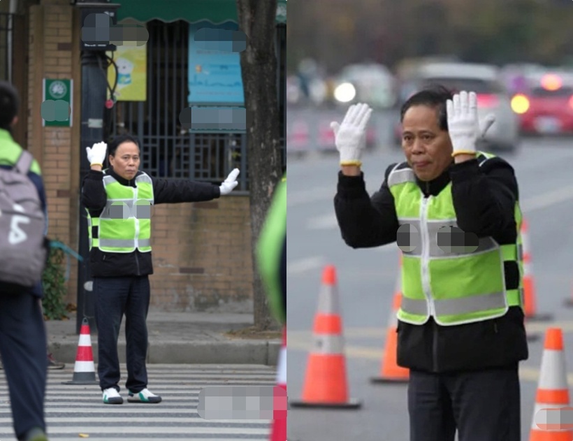 Thầy Ngô Bân đứng giữa đường, bảo vệ học sinh sang đường an toàn. Ảnh: Hangzhou Daily/QQ.