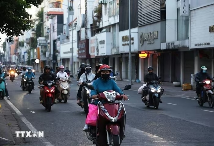 Người dân trong trang phục giữ ấm đi làm trên đường Hồ Văn Huê (phường Đức Nhuận) thời điểm 6h20 phút sáng 9/1/2026. (Ảnh: TTXVN).