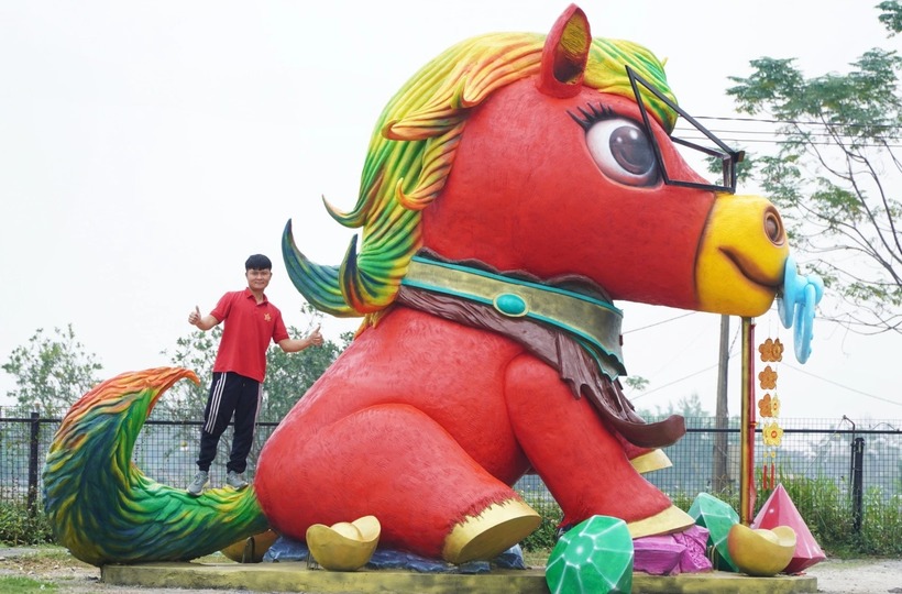 Anh Bùi Văn Quân bên cạnh linh vật "ngựa hạnh phúc". Ảnh: Vnexpress.