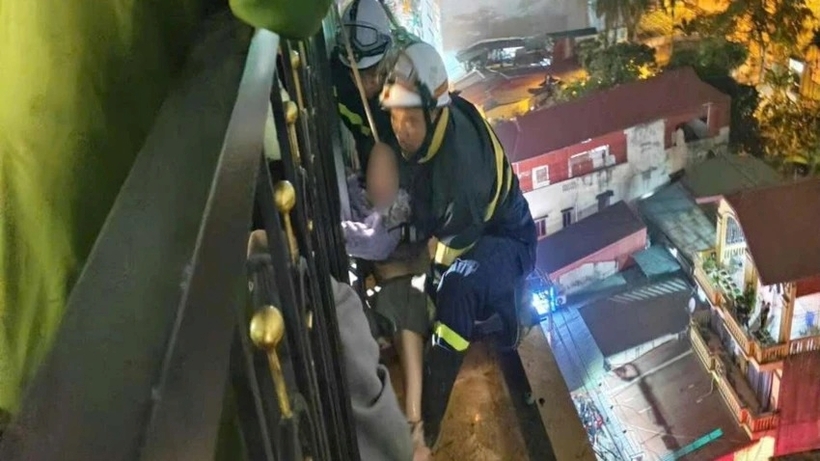 Lực lượng cảnh sát cứu nạn cứu hộ tiếp cận từ ngoài lan can tầng 9 giải cứu cô gái. Ảnh: Pháp luật TP.HCM