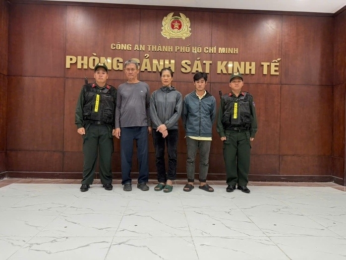 Vợ chồng bị can Nguyễn Duy Hiển (thứ hai từ trái sang) và Võ Văn Nghề (thứ hai từ phải sang) tại cơ quan điều tra. Ảnh: Người lao động